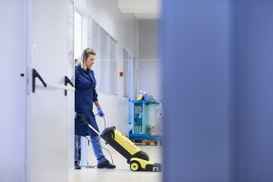 professional maid carpet cleaning and washing floor with machinery in industrial building. Carpet cleaning Bloomington IL 
